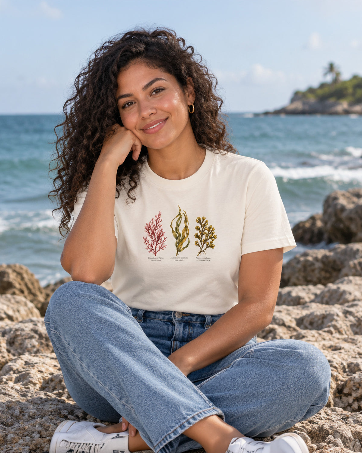 Woman wearing Atlantic Seaweed organic cotton T-shirt with Irish Moss, Oarweed and Bladderwrack botanical designed by Gaia's Harmony and pictured on the coast.