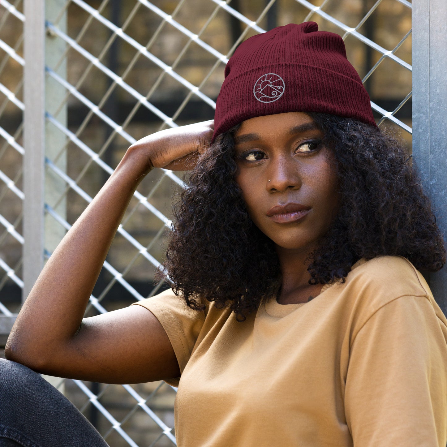 Lifestyle view of organic ribbed beanie with subtle embroidered Gaia’s Harmony logo – unisex beanie – color: burgundy
