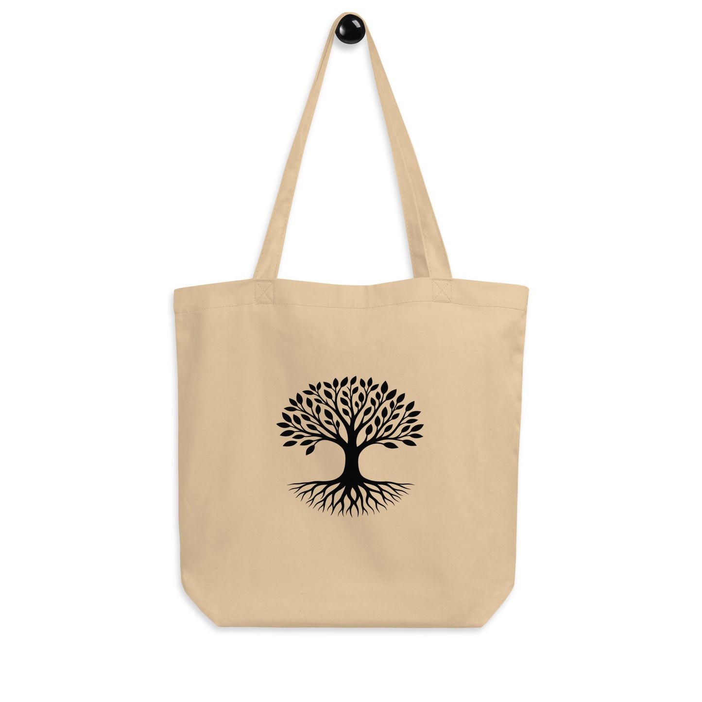 Hanging view of Tree of Life organic cotton tote bag in natural beige with black rooted tree graphic centered on front