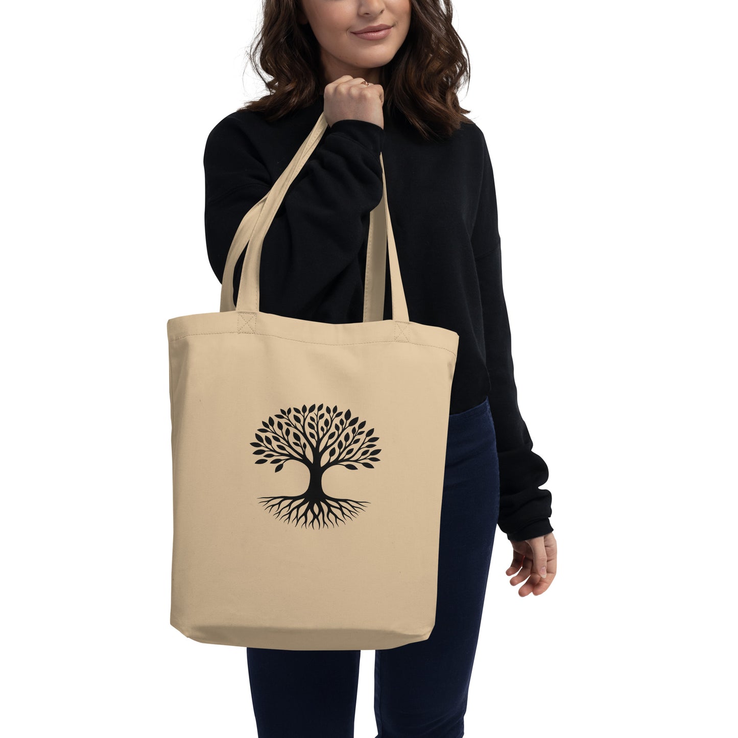 Lifestyle photo of Tree of Life organic cotton tote bag in natural beige with black rooted tree graphic centered on front